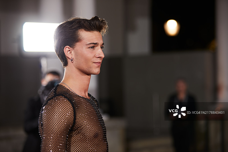 在红毯活动中，一位年轻男子为媒体拍照图片素材