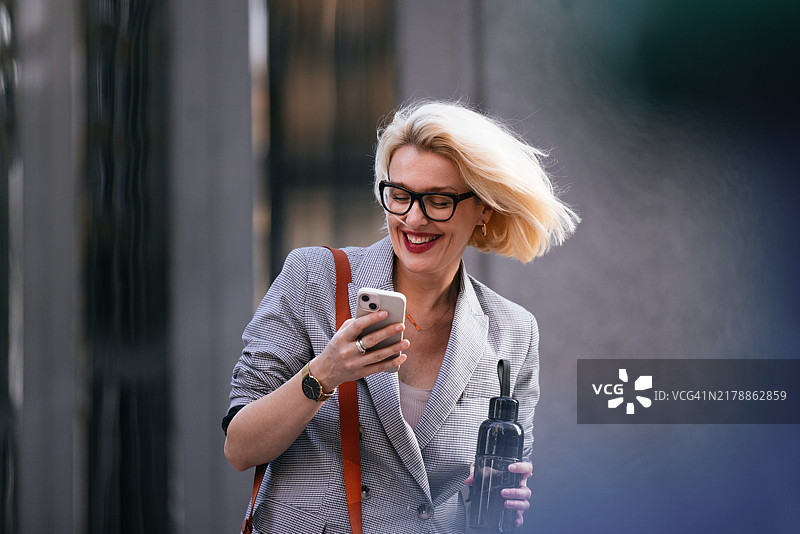 自信的女商人用智能手机享受城市生活方式图片素材