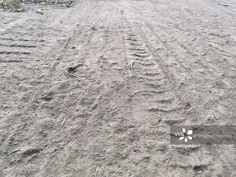 尘土飞扬的地面上的摩托车车轮印迹图片素材