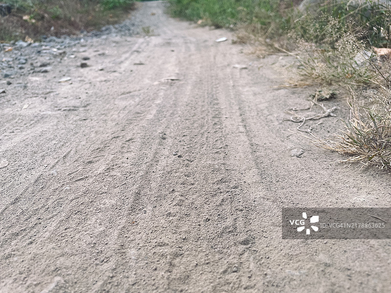 尘土飞扬的地面上的摩托车车轮印迹图片素材