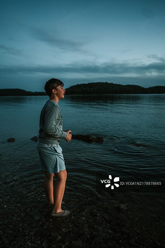 在美国奥扎克山脉的海滩上，男人全身站立，背景是天空。图片素材