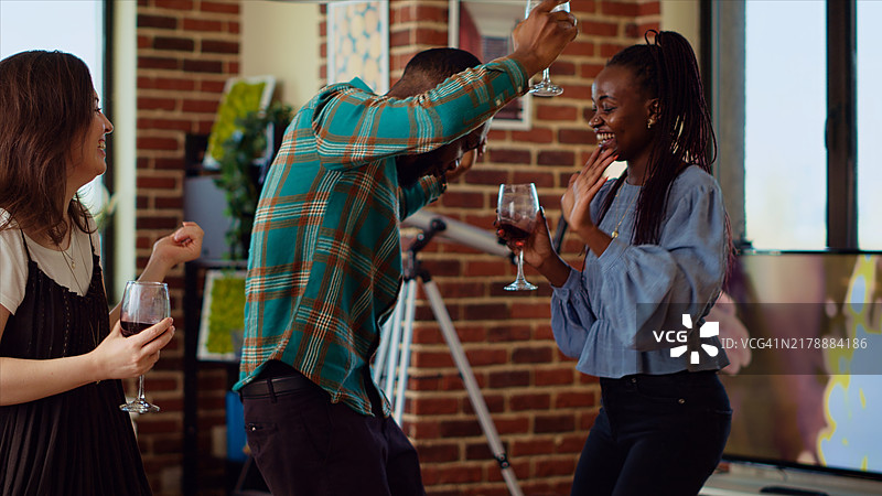 多元化的同事们在欢快的音乐中做着充满活力的舞蹈动作图片素材