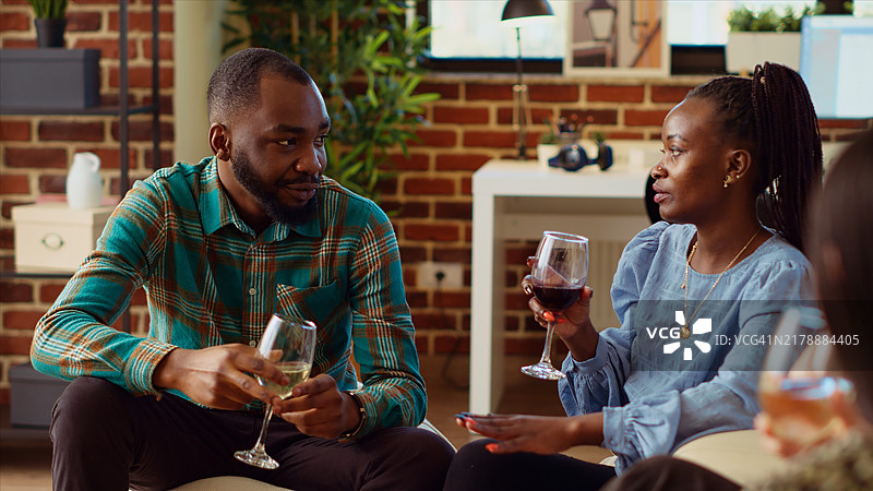 公寓派对上的男人与女人交谈，分享有趣的故事图片素材