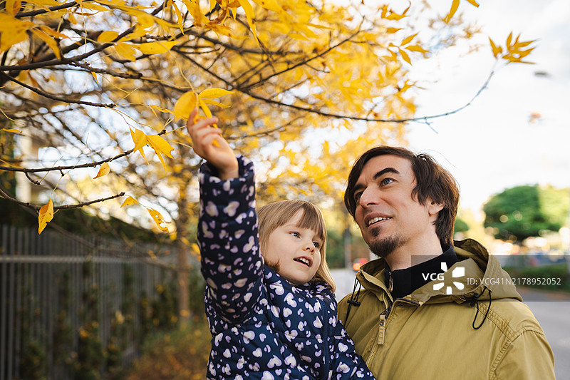 父女享受秋日散步时光图片素材