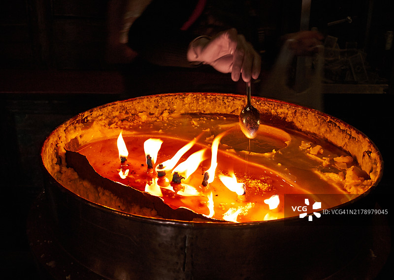 点燃容器内火焰的人的手部特写图片素材
