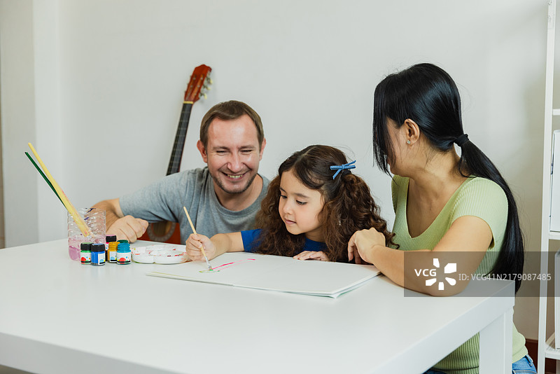 家庭在温馨的客厅中享受创意绘画时光，欢声笑语中学习与分享。图片素材