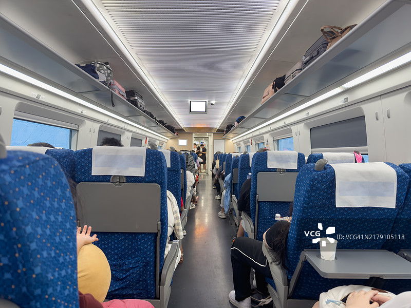 乘客们坐在火车车厢内等待出发。图片素材