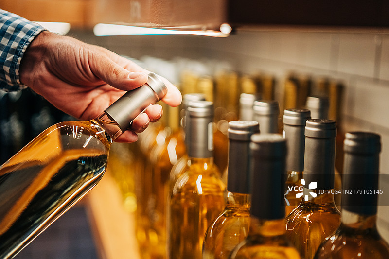 酒庄货架上的葡萄酒瓶，顾客正在挑选葡萄酒图片素材