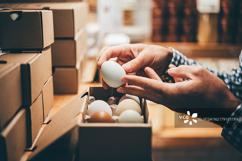 一个男人在农贸市场购买有机鸡蛋，装在纸箱里。图片素材