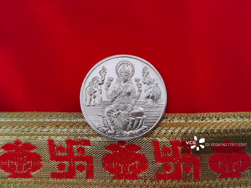 拉克希米女神银币与红色背景/Kalasha罐/万字符/Dhanteras/排灯节图片素材