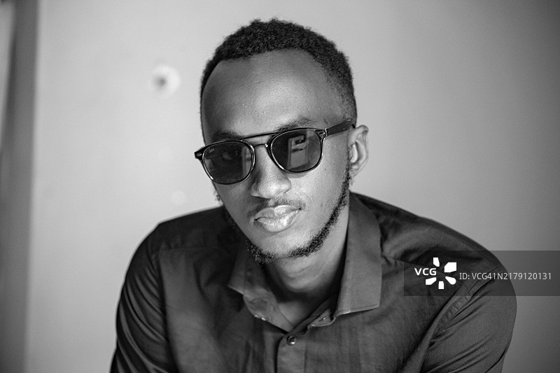 戴墨镜的自信年轻人黑白肖像图片素材