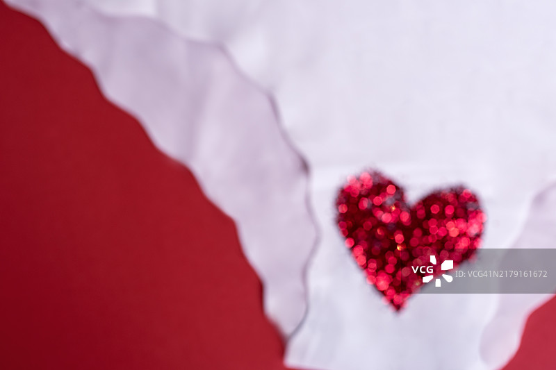 红色背景上的白色内裤特写，月经概念图片素材