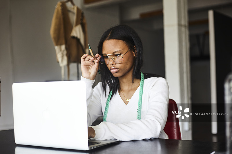 在工位使用笔记本电脑的年轻女人图片素材