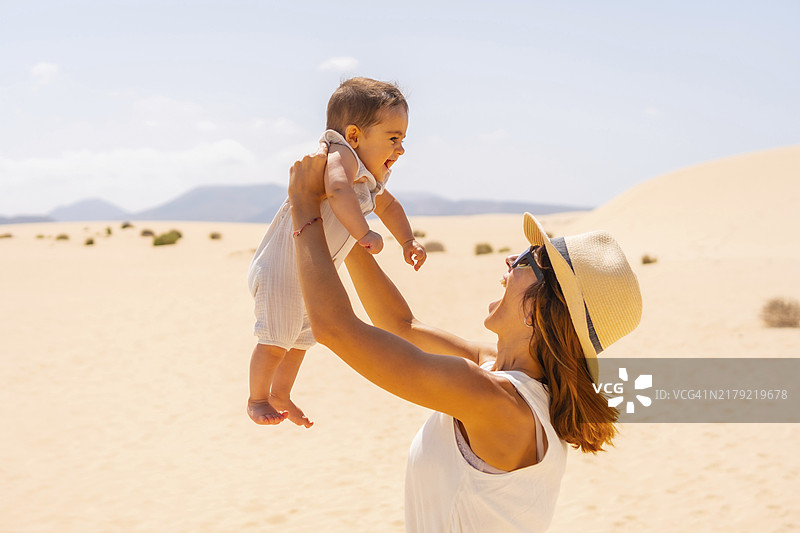 年轻母亲在西班牙富埃特文图拉岛科拉莱霍自然公园的沙丘上与儿子度假图片素材