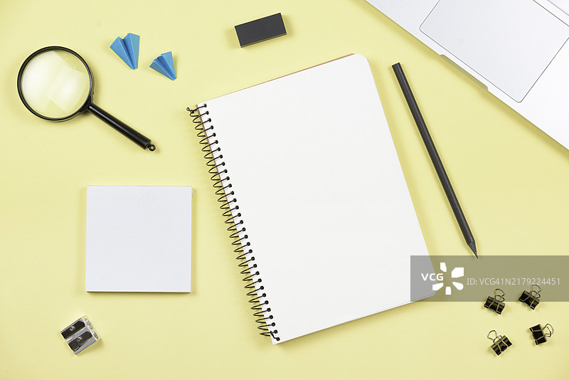 黄色背景上的笔记本电脑办公用品俯视图图片素材