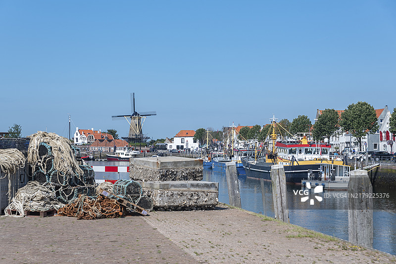 新哈芬码头的拖网渔船，背景是荷兰泽兰省济里克泽的“登哈斯”风车图片素材