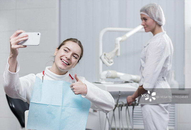 快乐的年轻女人与牙医自拍图片素材