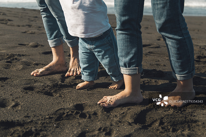 父母和宝宝在沙滩海岸线上行走图片素材