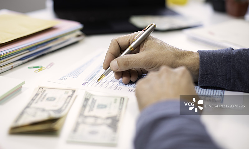 男子在家填写税务表格的特写图片素材