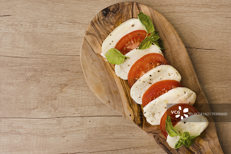 意大利卡普雷塞沙拉配马苏里拉奶酪片、罗勒和番茄顶视图图片素材