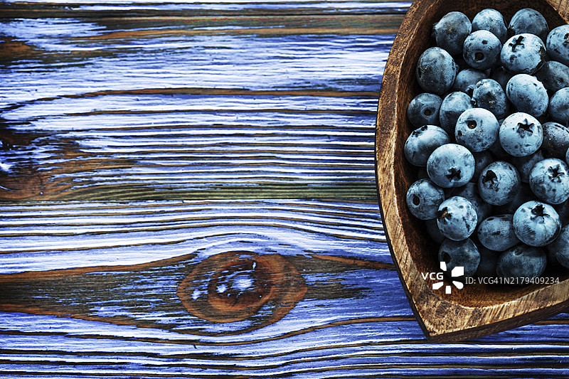 心形木碗中的越橘图片素材