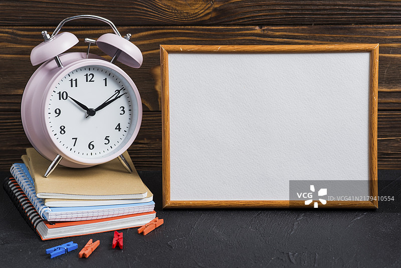 白色写字板闹钟衣服挂钉笔记本黑色桌子图片素材