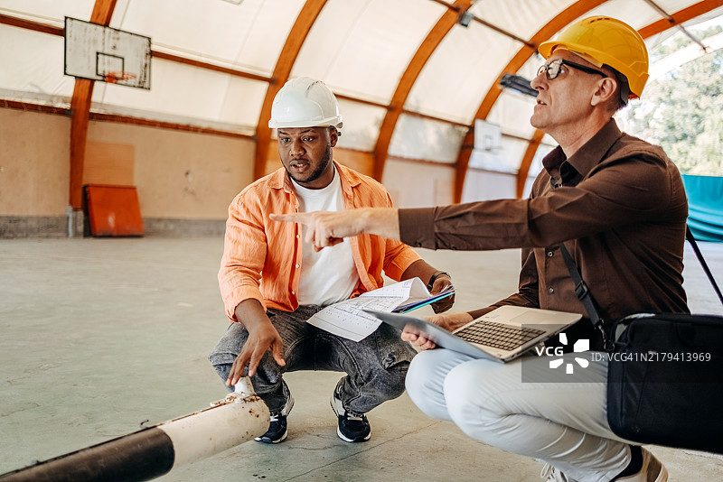 保险代理人在建筑工地检查损坏情况图片素材