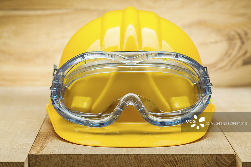 安全工具，木板上的黄色施工头盔和蓝色安全护目镜图片素材