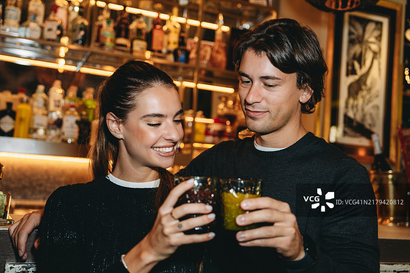 幸福情侣在酒吧享用鸡尾酒图片素材