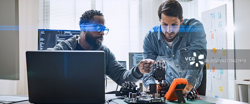 男性软件开发程序员合作编写机器人手臂程序图片素材