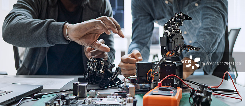 男性软件开发程序员合作编写机器人手臂程序图片素材