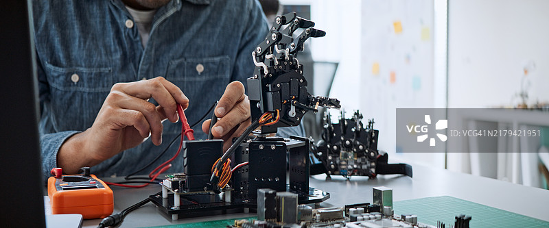 男性软件开发程序员合作编写机器人手臂程序图片素材