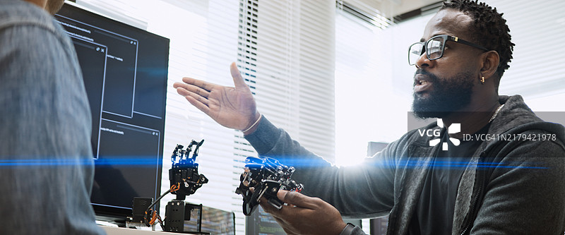 男性软件开发程序员合作编写机器人手臂程序图片素材