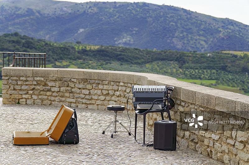 街头乐手演奏手风琴，背景为山地景观图片素材