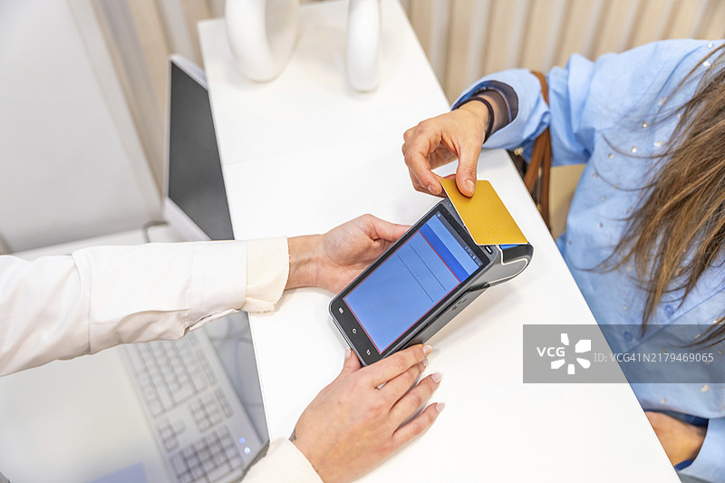 美容院内，一位女士用信用卡支付顶视图图片素材