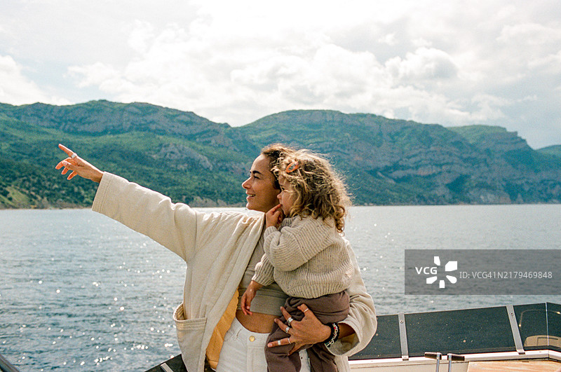 小女孩和母亲在船上欣赏海上美景图片素材