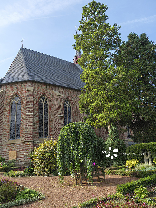 蓝天下绿树环绕的教堂，德国威斯特法伦图片素材