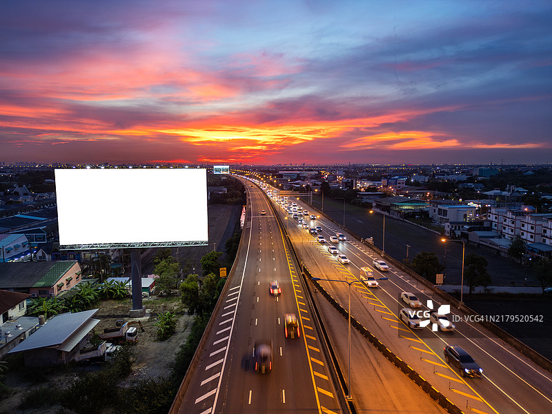日落时分带有车流的高速公路广告牌图片素材