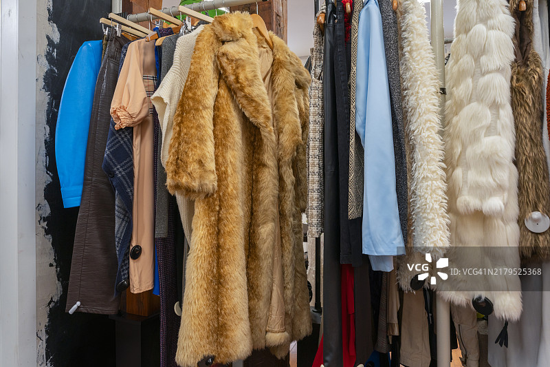精品店内的复古毛皮大衣和冬季服装，焦点是一件棕色狐皮大衣，突显二手服装的魅力。西班牙图片素材