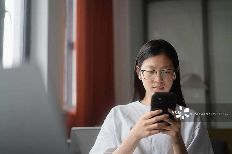 使用智能手机的亚洲女学生图片素材