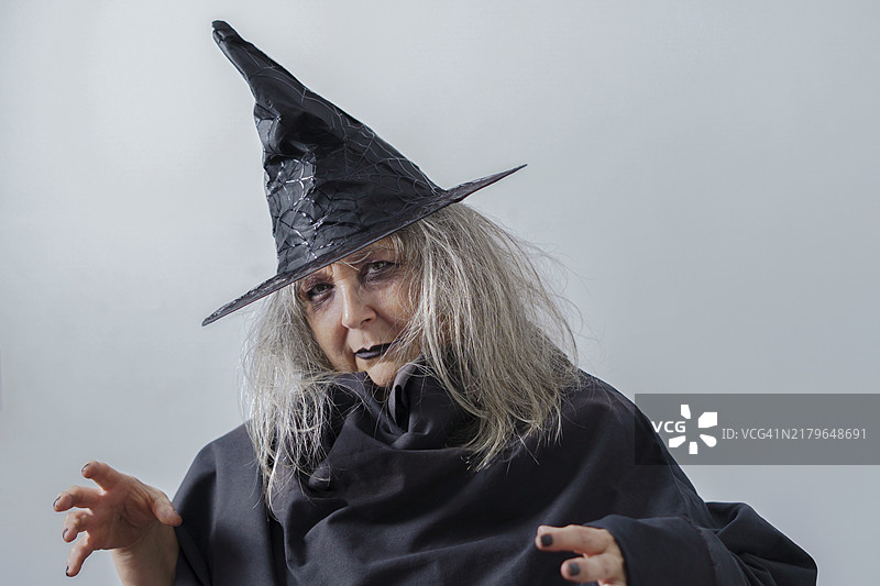 浅色背景上戴着黑色帽子的白发老巫婆图片素材