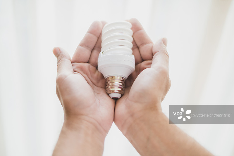特写：手持节能灯泡图片素材