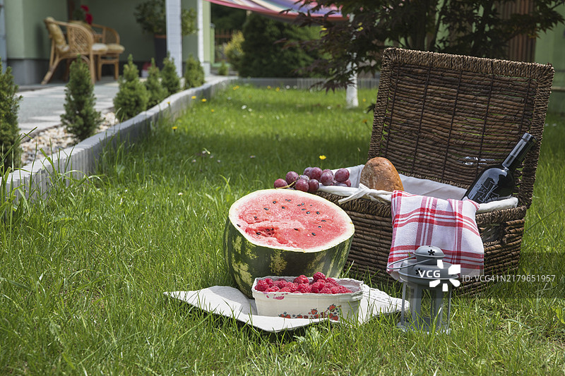 装满水果的野餐篮，绿色草地图片素材