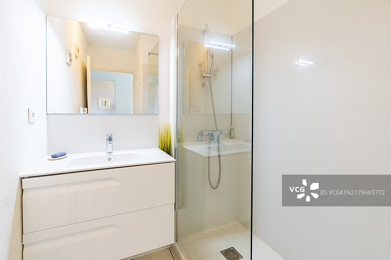 家庭浴室：带瓷砖玻璃淋浴的明亮新浴室图片素材