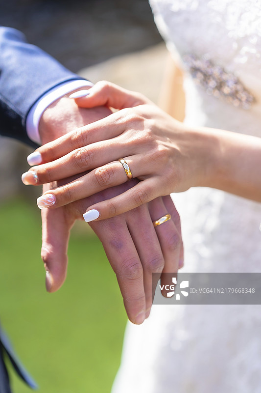 美丽婚礼上新娘和新郎戴着戒指的手部细节，结婚典礼图片素材