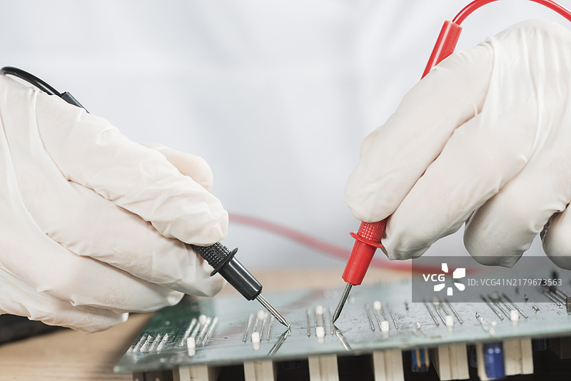 技术人员用数字万用表检查计算机电路板特写图片素材