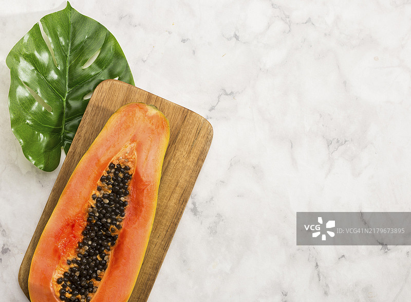 极简主义半个木瓜龟背竹叶图片素材