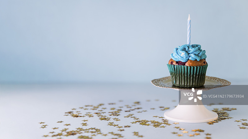 蓝色背景下的纸杯蛋糕烛台图片素材