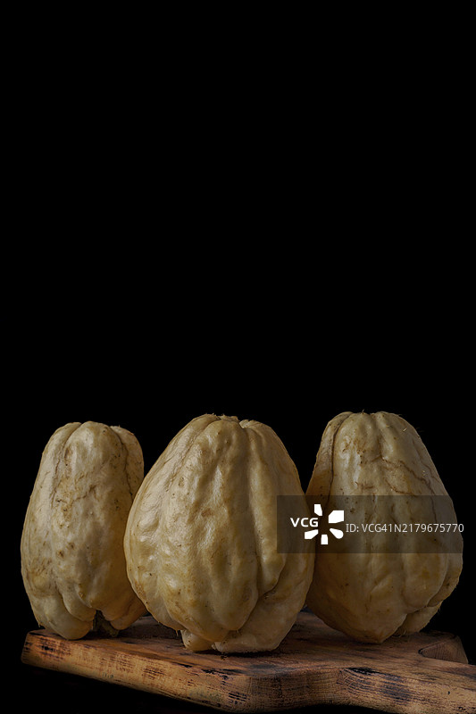 黑色背景木板上的佛手瓜图片素材