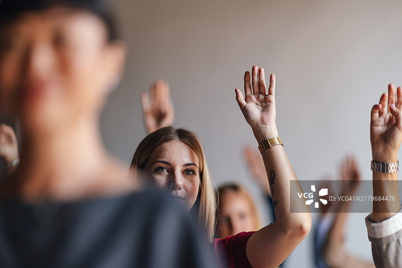 互动商务研讨会上积极举手的观众。图片素材